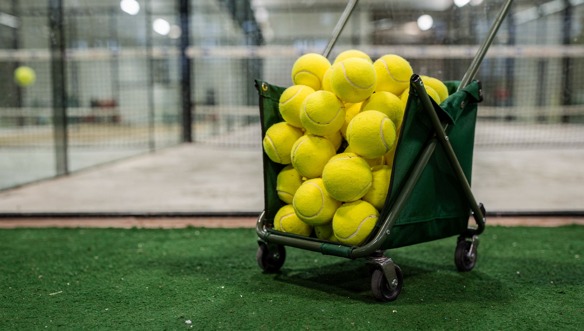 AI illustration of a wheeled basket of yellow balls in a generic indoor playing space.